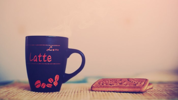Latte mug with coffee beans and a biscuit