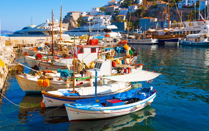 Boats docked in a harbor with a town on a hill