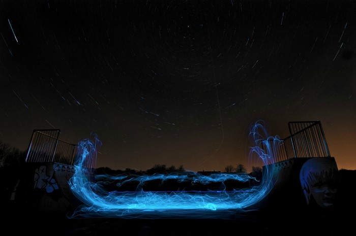 Light painting in skatepark at night with star trails