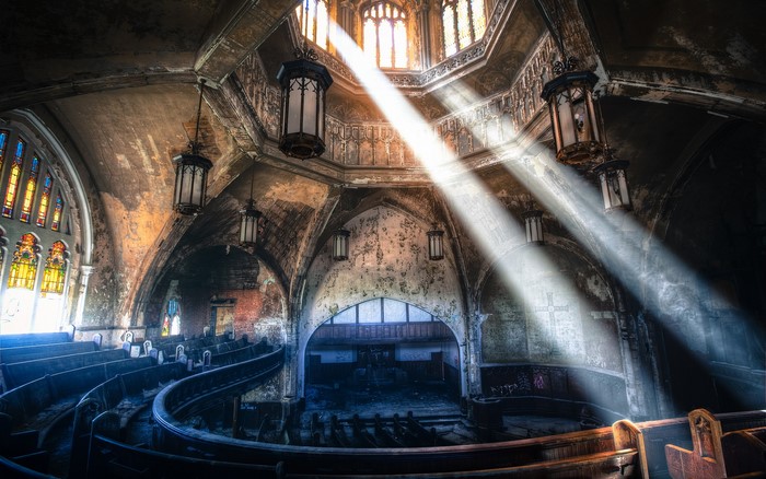 Abandoned church interior with sunbeams and stained glass