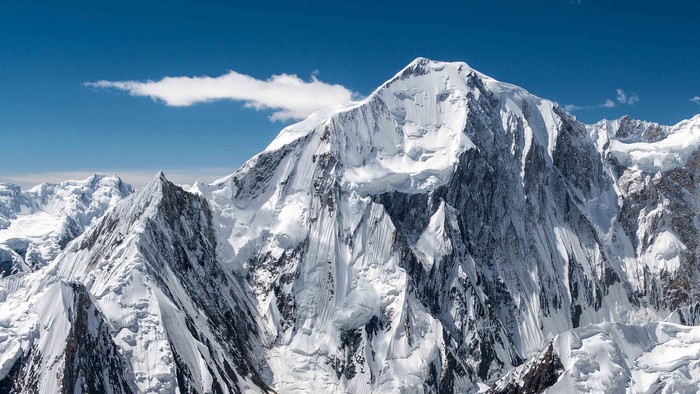 Snow-covered mountain range under a blue sky