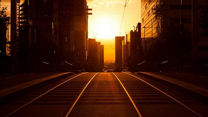 Tram tracks in a city at sunset