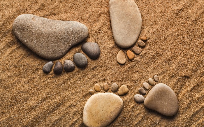 Footprints made of stones on sand