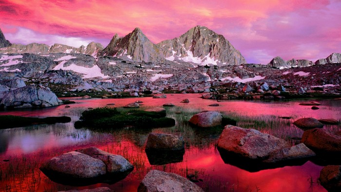 Mountain lake reflecting pink sky