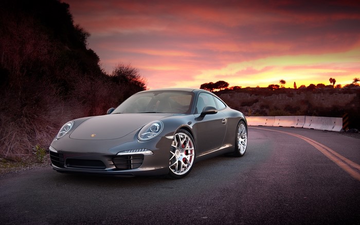 Porsche 911 on a road at sunset