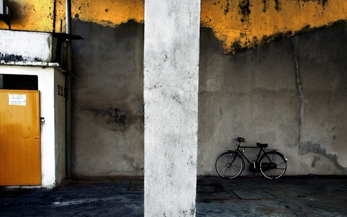 Bicycle parked against a textured wall