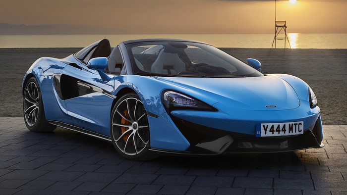 Blue McLaren 570S Spider convertible sports car on beach