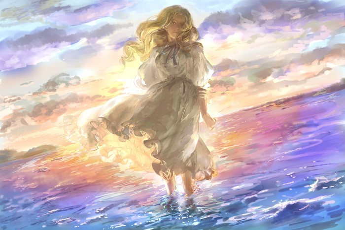 Girl in a white dress standing in the ocean at sunset