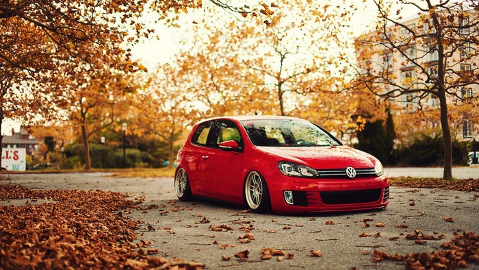 Red Volkswagen Golf parked in autumn