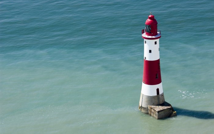 Red and white lighthouse in the ocean