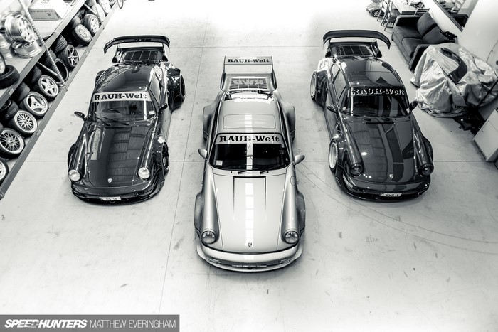 Three Porsche 911 RAUH-Welt cars in a workshop