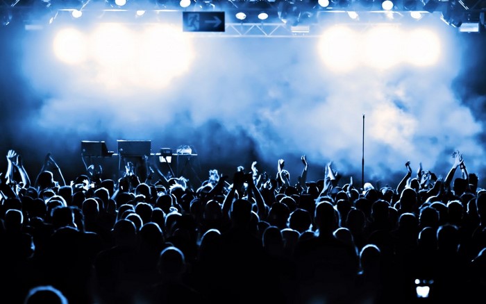 Concert crowd with stage lights and smoke
