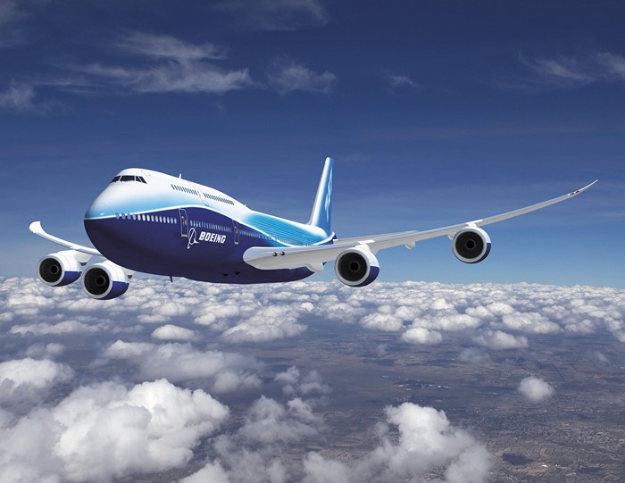 Boeing 747 aircraft flying above clouds