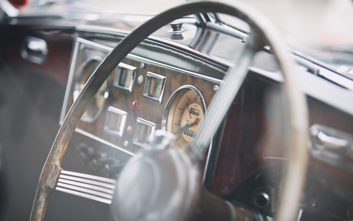 Close up of a vintage car dashboard and steering wheel