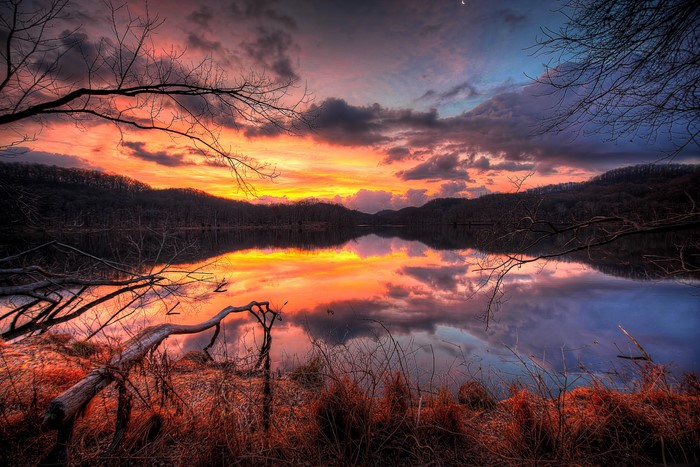 Sunset over a calm lake with dramatic clouds