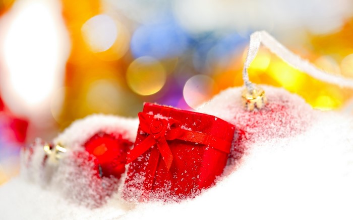Christmas ornaments and gift box in snow