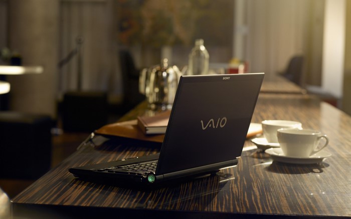 Sony Vaio laptop on a wooden table with coffee cups