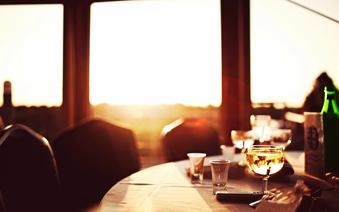 Table setting with wine glasses and bottle at sunset