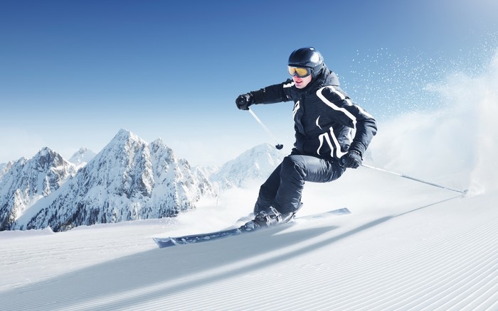 Skier in black and white ski suit on snowy mountain