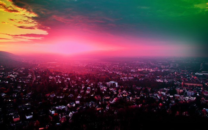 Aerial view of a city at sunset with colorful sky