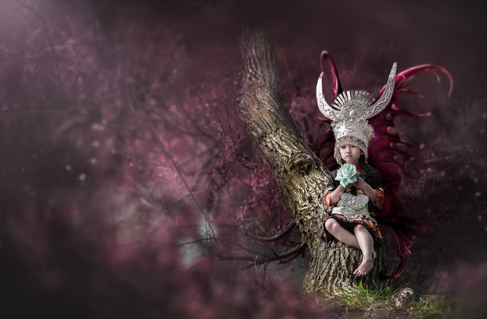 Asian girl in costume sitting on a tree