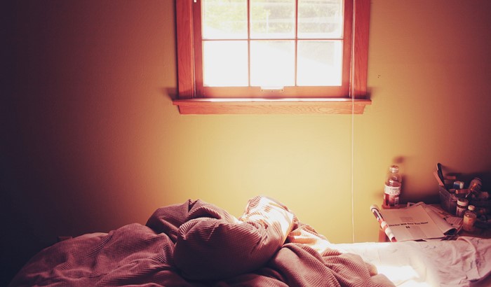 Bedroom with a window and a messy bed