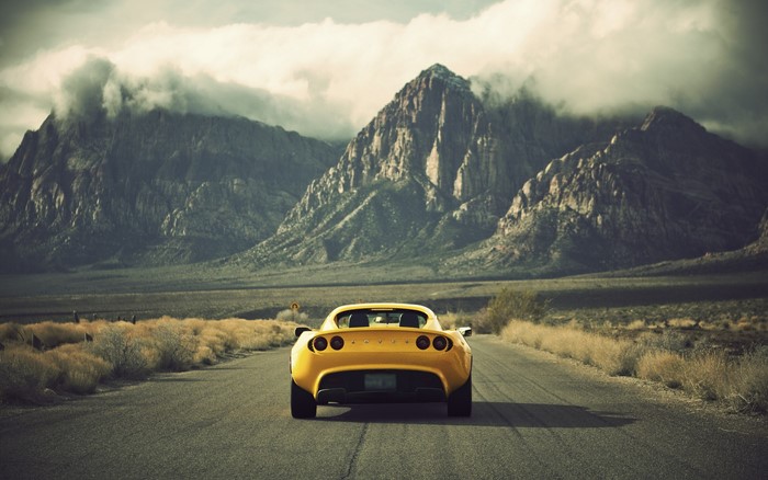 Yellow Lotus Car on a Desert Road with Mountains
