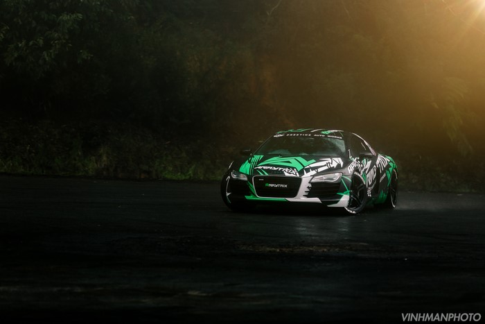 Audi R8 with green and white graphics on a wet road