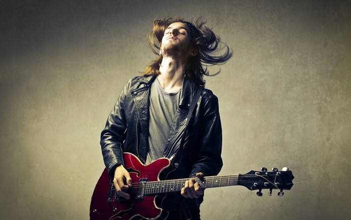 Man playing a red electric guitar