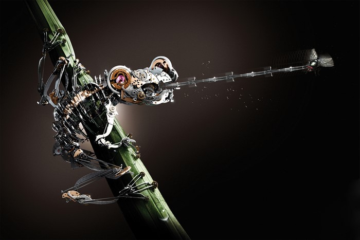 Mechanical frog catching a fly on a bamboo stalk