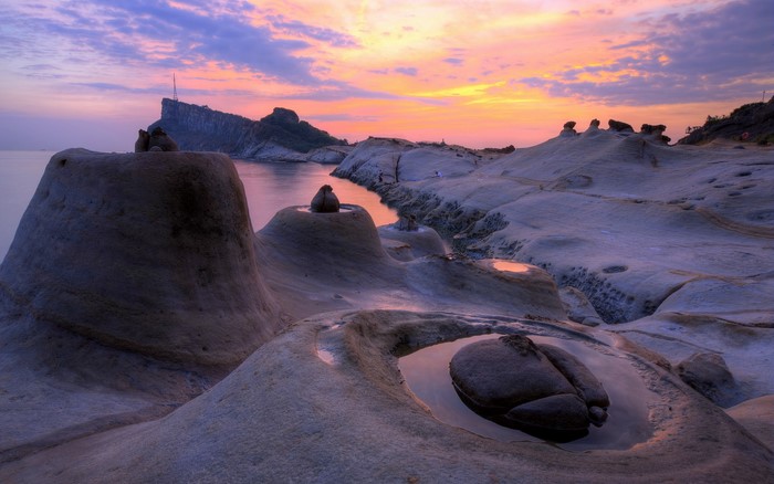 Rocky coastline at sunset with colorful sky