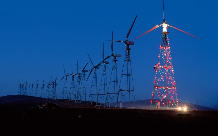 Wind turbines decorated with Christmas lights at night
