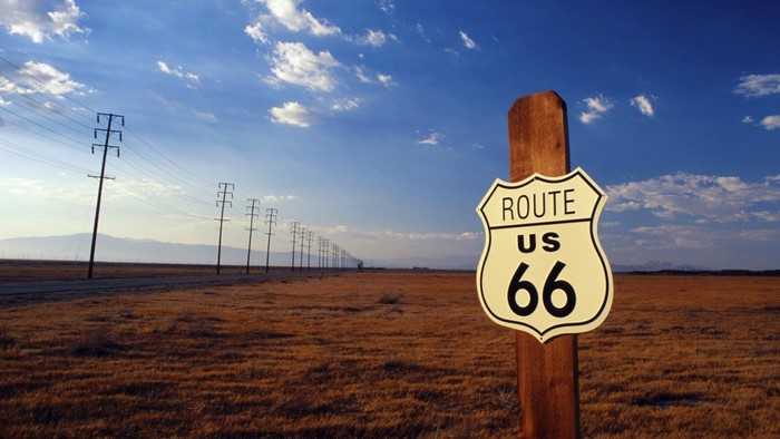 Route 66 sign in a dry landscape with power lines