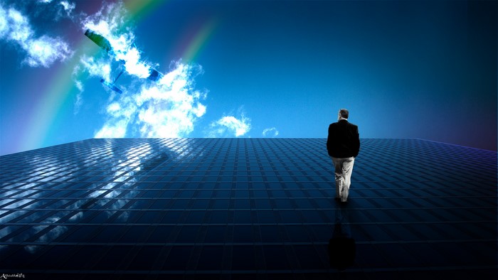 Man on skyscraper looking at rainbow and kite