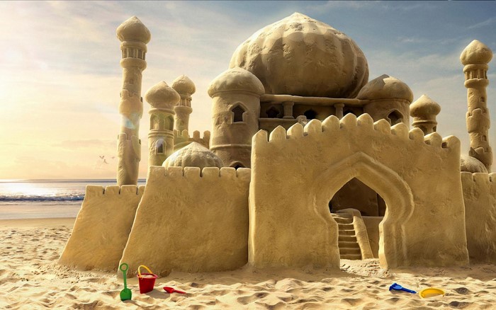 Sandcastle resembling a mosque on a beach