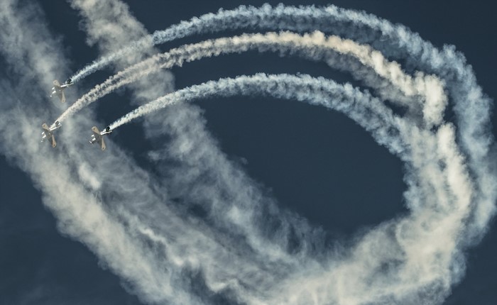 Three planes perform aerobatics with smoke trails