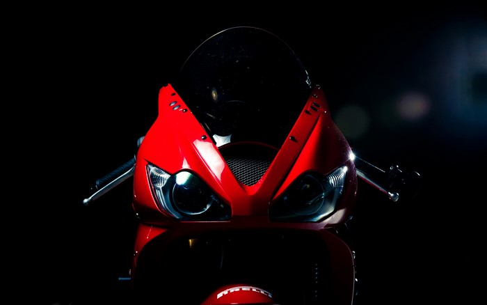 Red motorcycle front view on black background