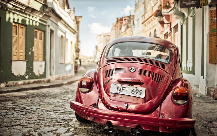 Red Volkswagen Beetle on Cobblestone Street