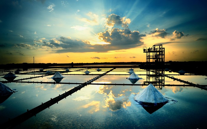 Salt fields at sunset with reflection