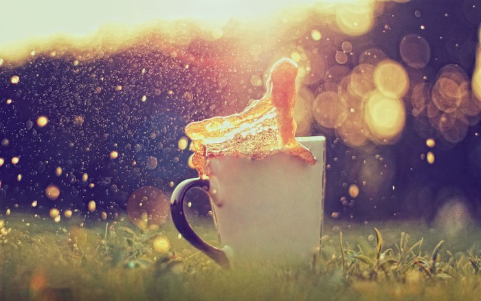 Coffee splashing out of a cup in bokeh lighting