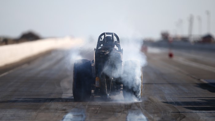 Dragster performing a burnout on a race track