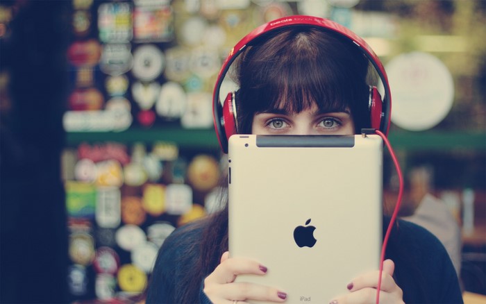 Girl with headphones holding an iPad
