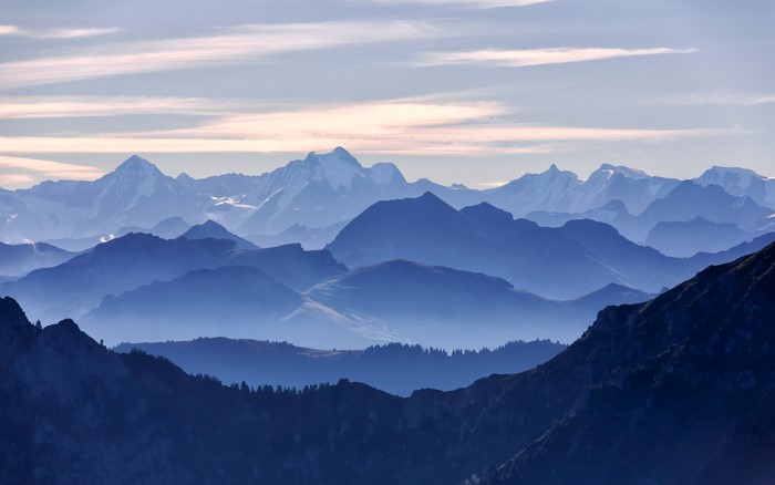 Layered Blue Mountains with Fog and Snow