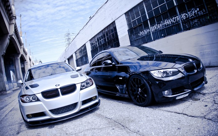 Two BMW coupes parked on a street