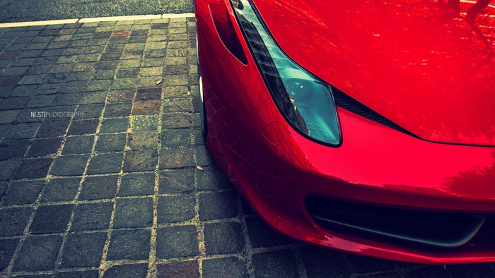 Red Ferrari 612 GTO parked on cobblestone street