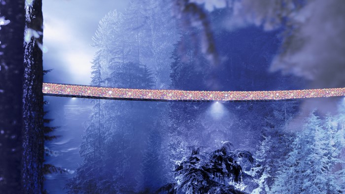 Bridge decorated with Christmas lights in a snowy forest