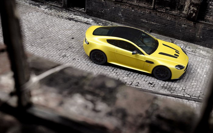 Yellow Aston Martin Vantage on Cobblestone Street