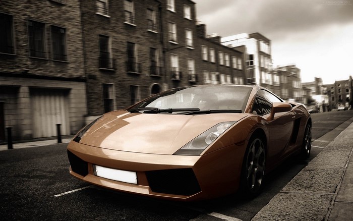 Orange Lamborghini driving on a city street