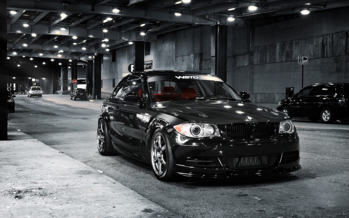 Black BMW coupe with red interior parked on city street