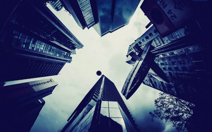 Low angle view of skyscrapers against cloudy sky
